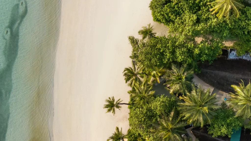 Vue aérienne de la Beach Villa du Constance Halaveli Maldives, plage de sable blanc, végétation tropicale et lagon turquoise 