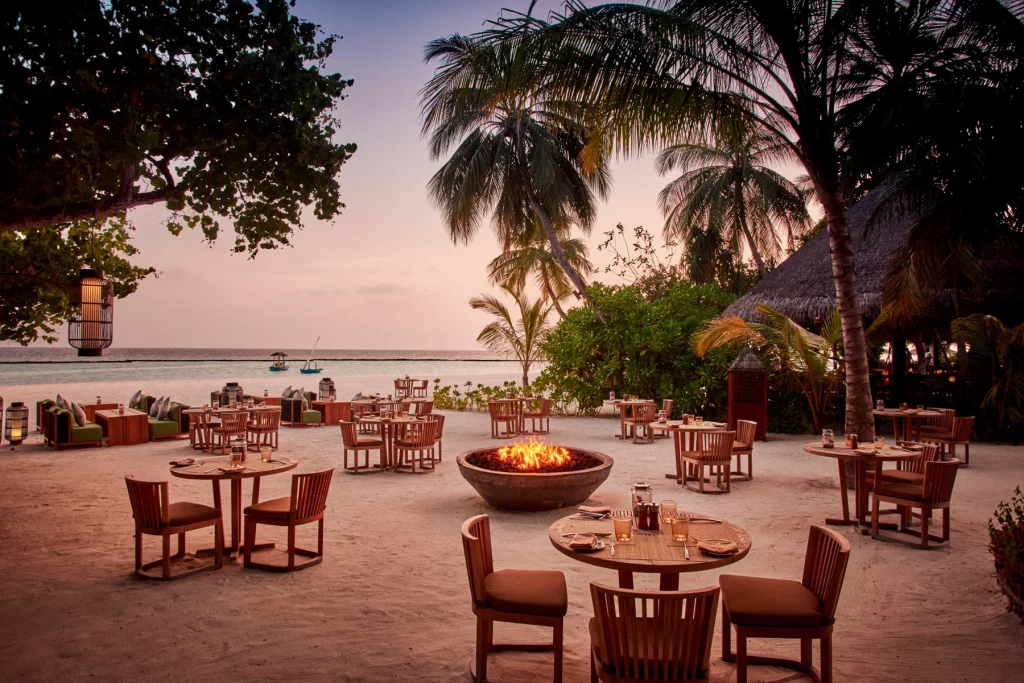 Restaurant du Constance Halaveli Maldives avec vue sur le lagon, table élégante et ambiance gastronomique de luxe.