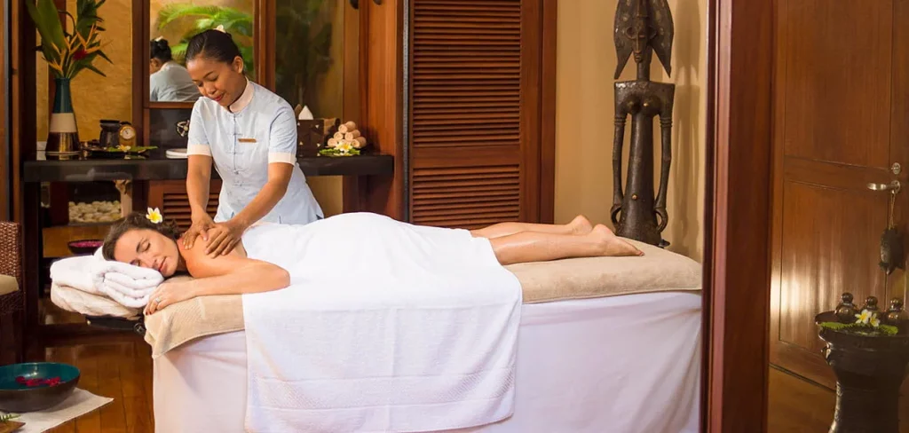 Spa du The Oberoi Beach Resort Mauritius, salle de massage avec thérapeute professionnelle et ambiance tropicale relaxante.