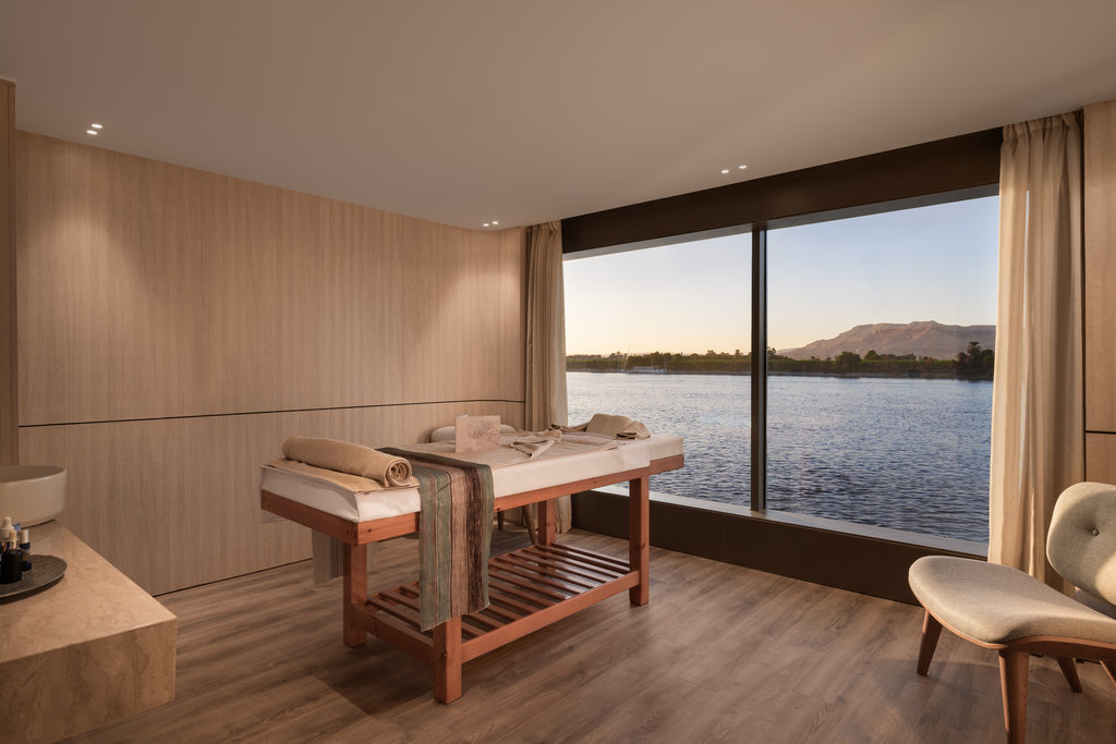 Salle de soin du spa du Storia the Dahabeya avec table de massage et grande baie vitrée donnant sur le Nil