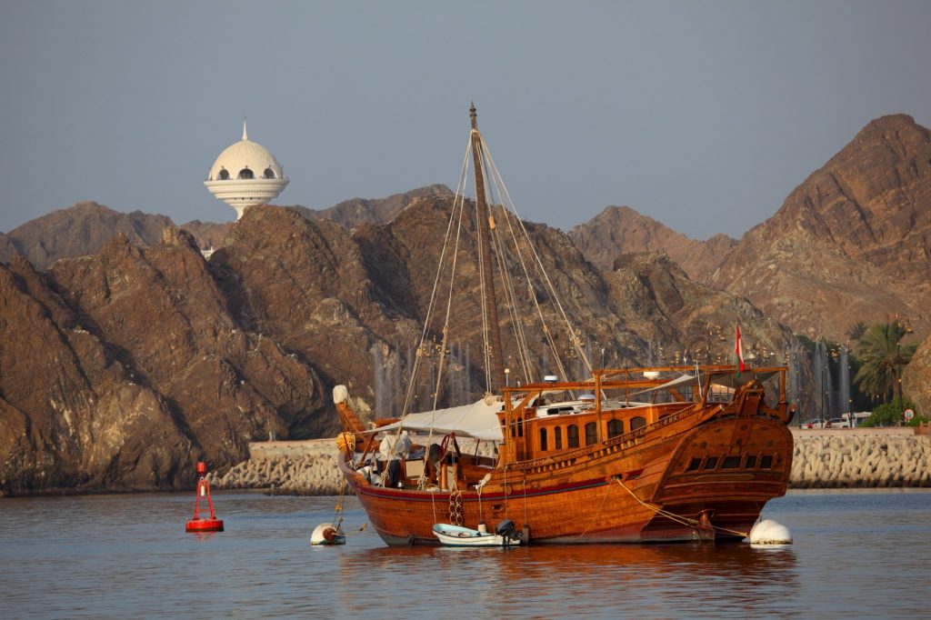 Fin de voyage privatif à Oman à Mascate, boutre traditionnel face aux montagnes