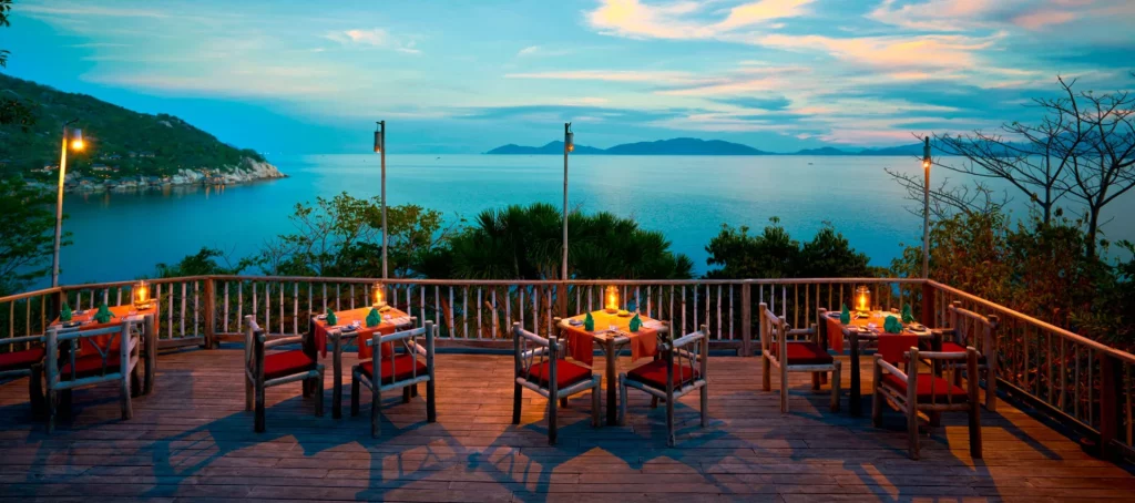 Restaurant avec vue panoramique sur la mer au coucher du soleil dans une baie au Vietnam
