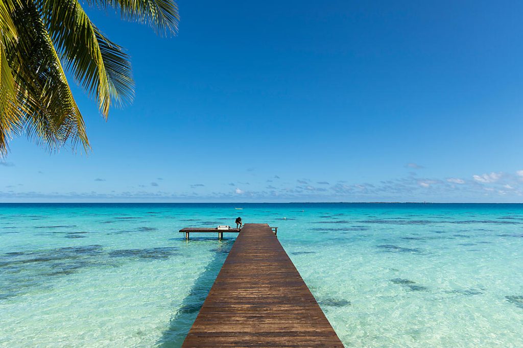 Croisière Ponant en Polynésie avec ponton en bois sur un lagon turquoise et eau cristalline