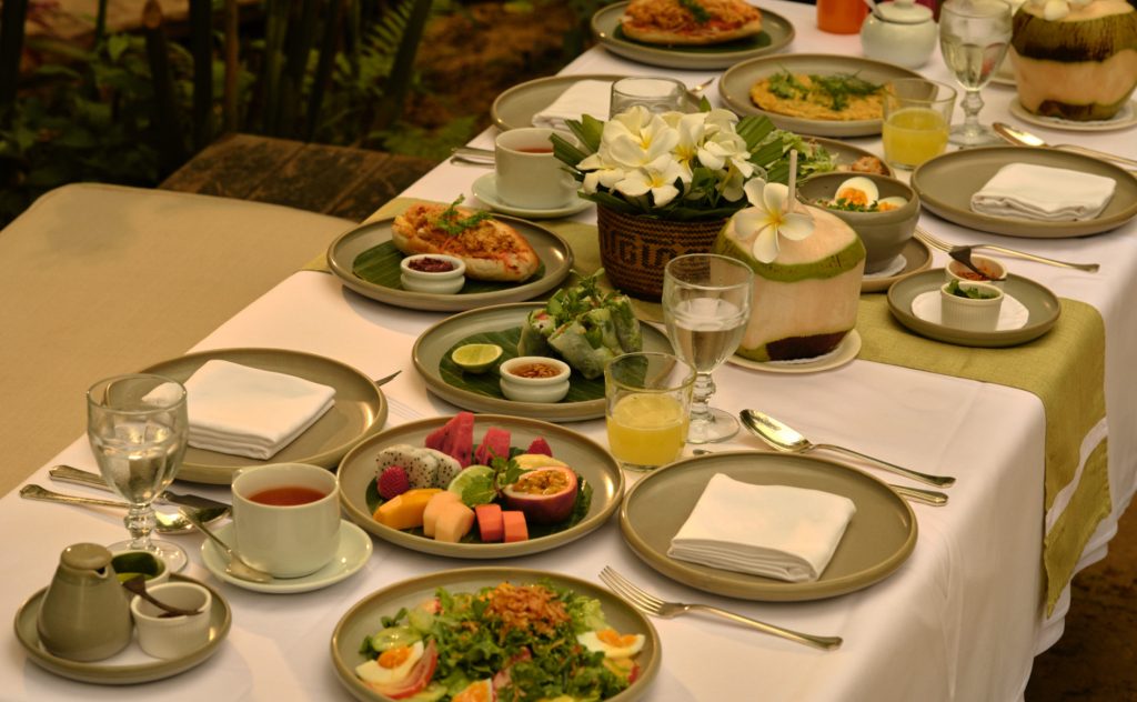 Cuisine royale lao à Amantaka avec assiettes partagées et saveurs laotiennes