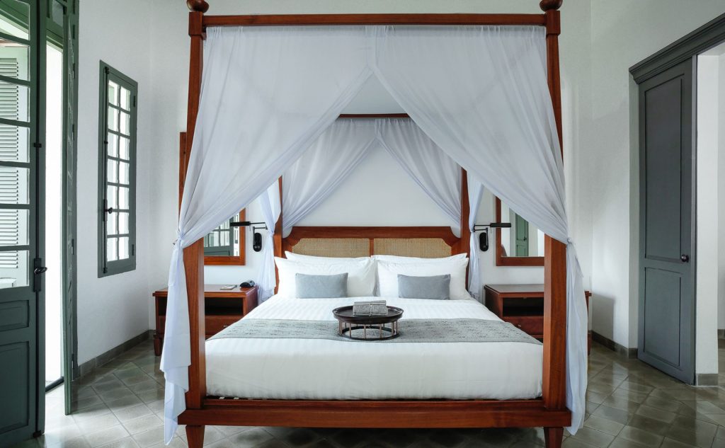 Chambre de la Pool Suite à Amantaka avec lit à baldaquin à Luang Prabang