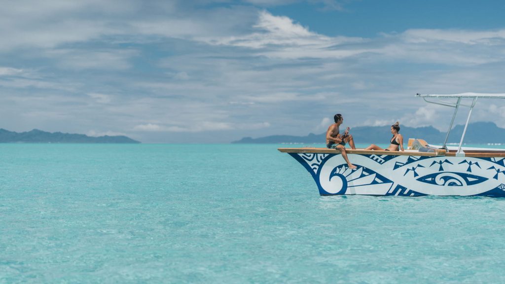 Couple sur un bateau privé dans le lagon turquoise de Bora Bora